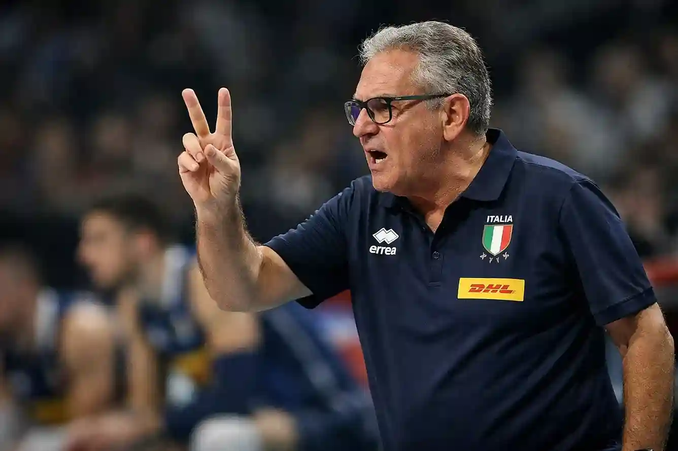 Allenatore della nazionale italiana di pallavolo che dà istruzioni tattiche durante una partita
