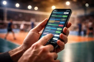 Mano che tiene uno smartphone con schermo acceso durante una partita di pallavolo in uno stadio