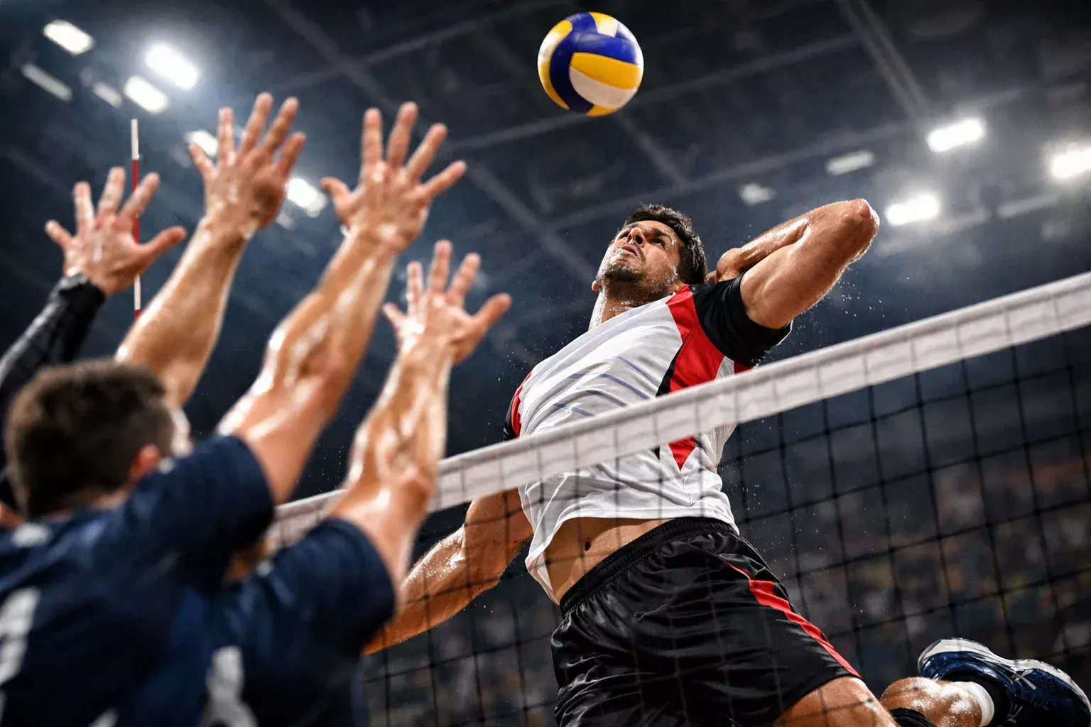 Schiacciatore di pallavolo in volo durante un attacco potente contro il muro avversario