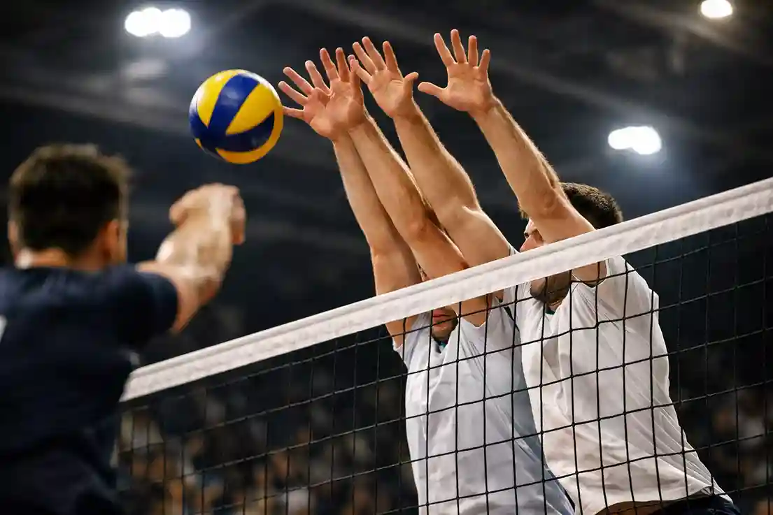 Due giocatori di pallavolo che formano un muro difensivo a rete