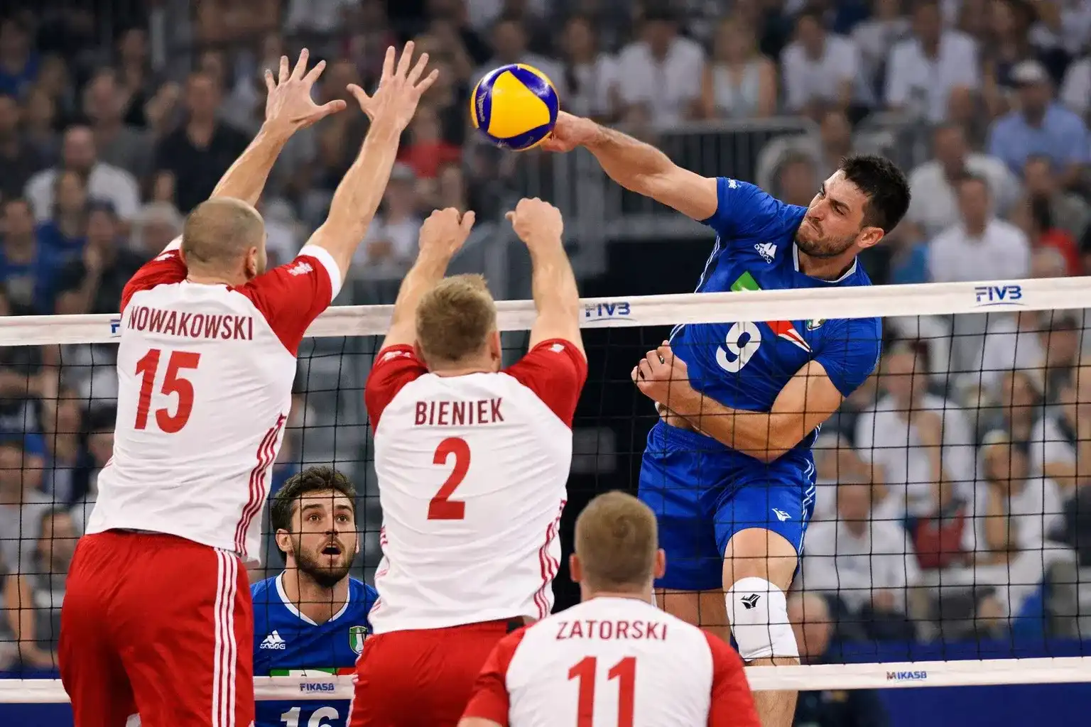 Azione intensa durante una partita Italia-Polonia di pallavolo maschile